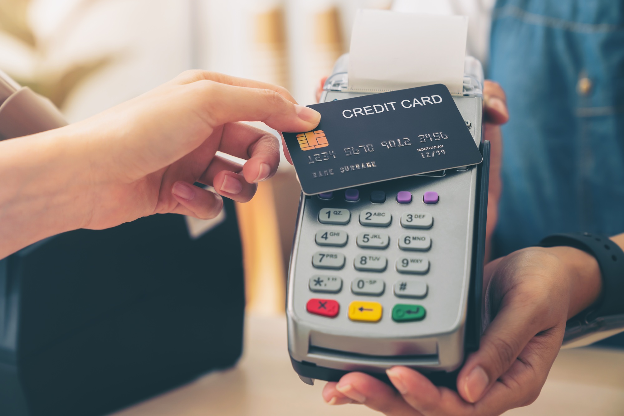 Customer using credit card for payment by NFC technology to owner at restaurant.