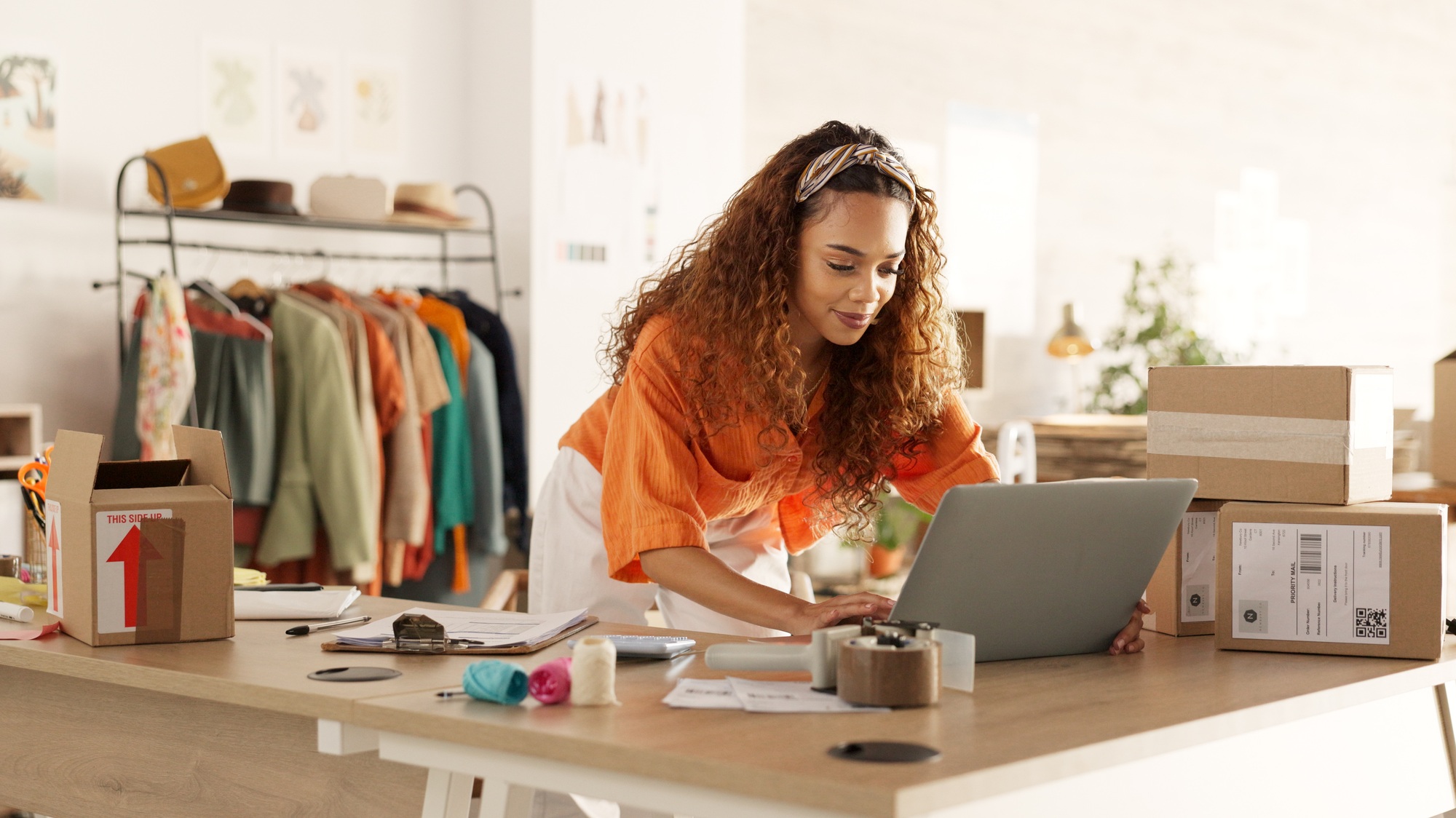 Logistics, laptop and fashion manager of retail or boutique shop checking clothing stock in boxes o