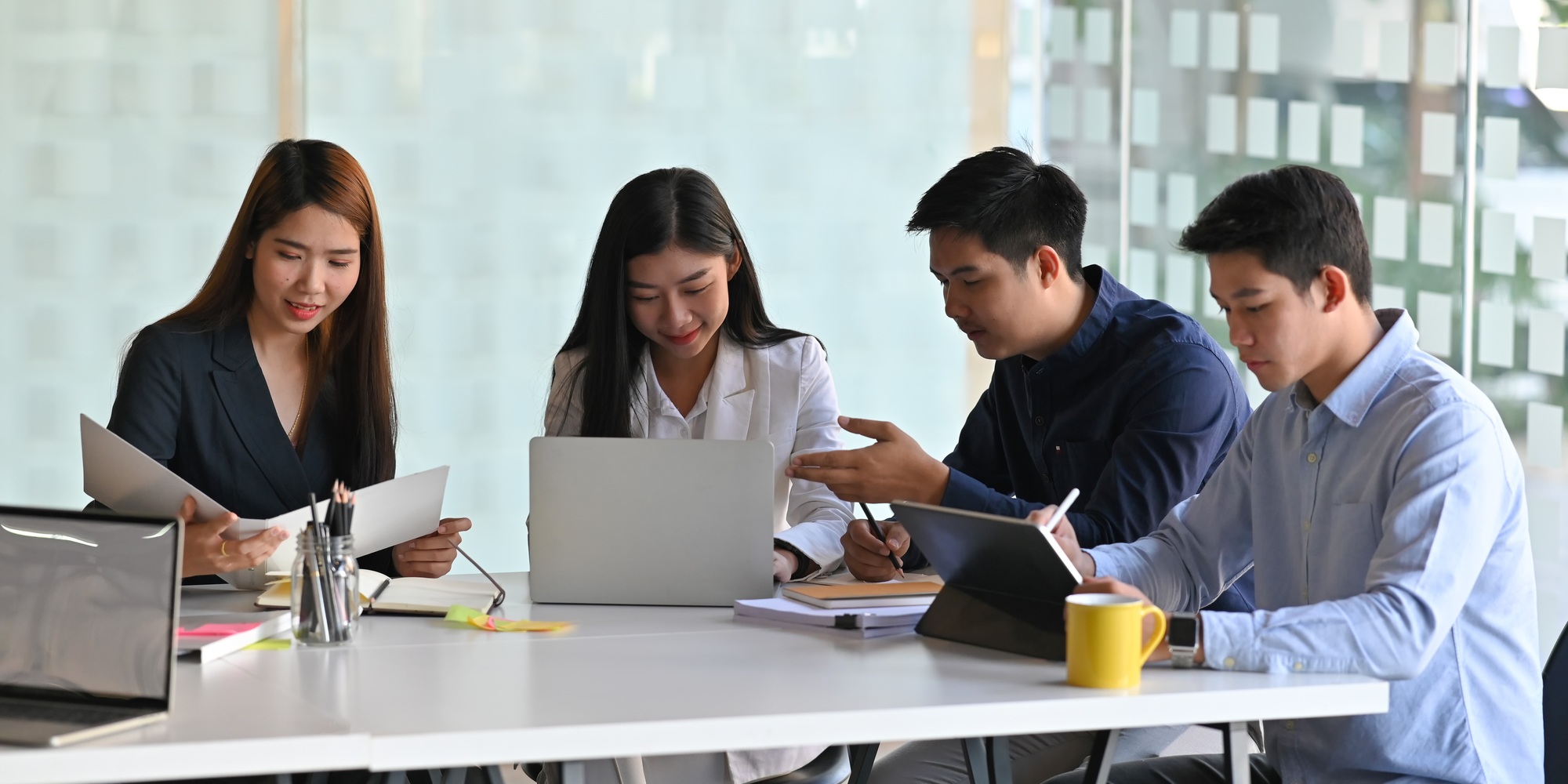 Photo of business people meeting with computer laptop and tablet while sitting together.